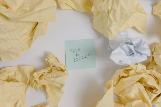 A top view of crumpled papers surrounding a sticky note with 'Take a Break'.